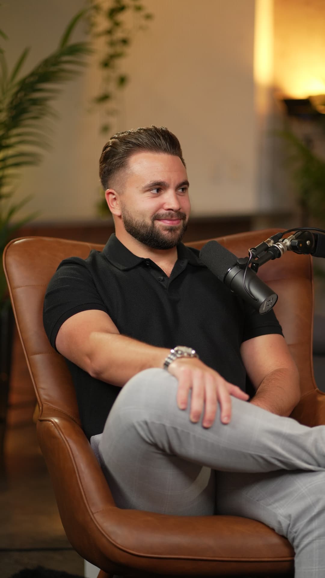 Shayne seated in a leather chair in front of a podcast microphone